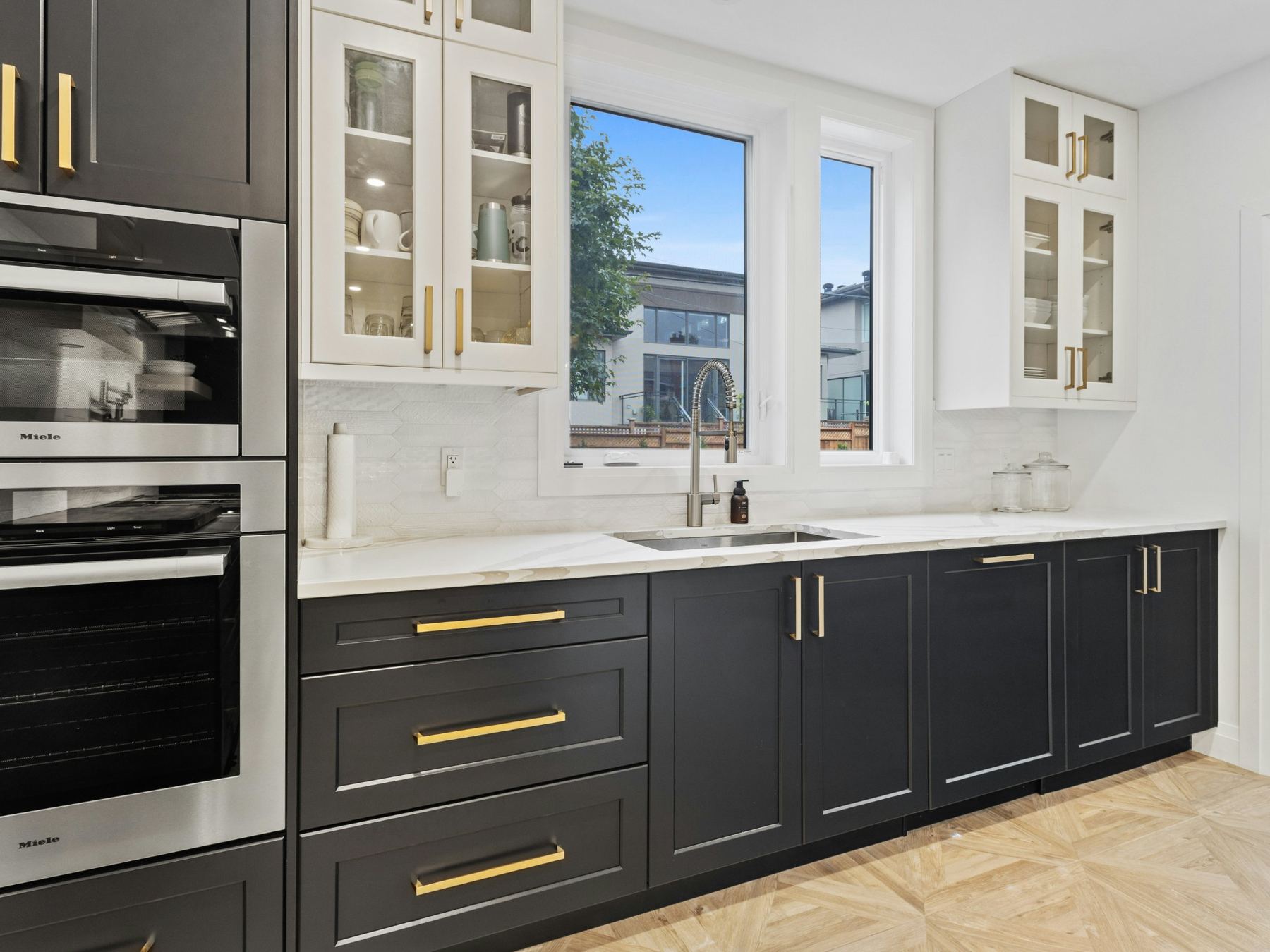 Kitchen with black shaker cabinets and brass pulls